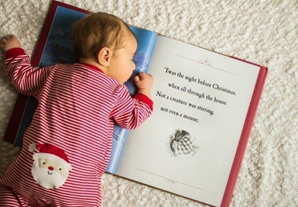 newborn baby laying on the Christmas book - the night before Christmas